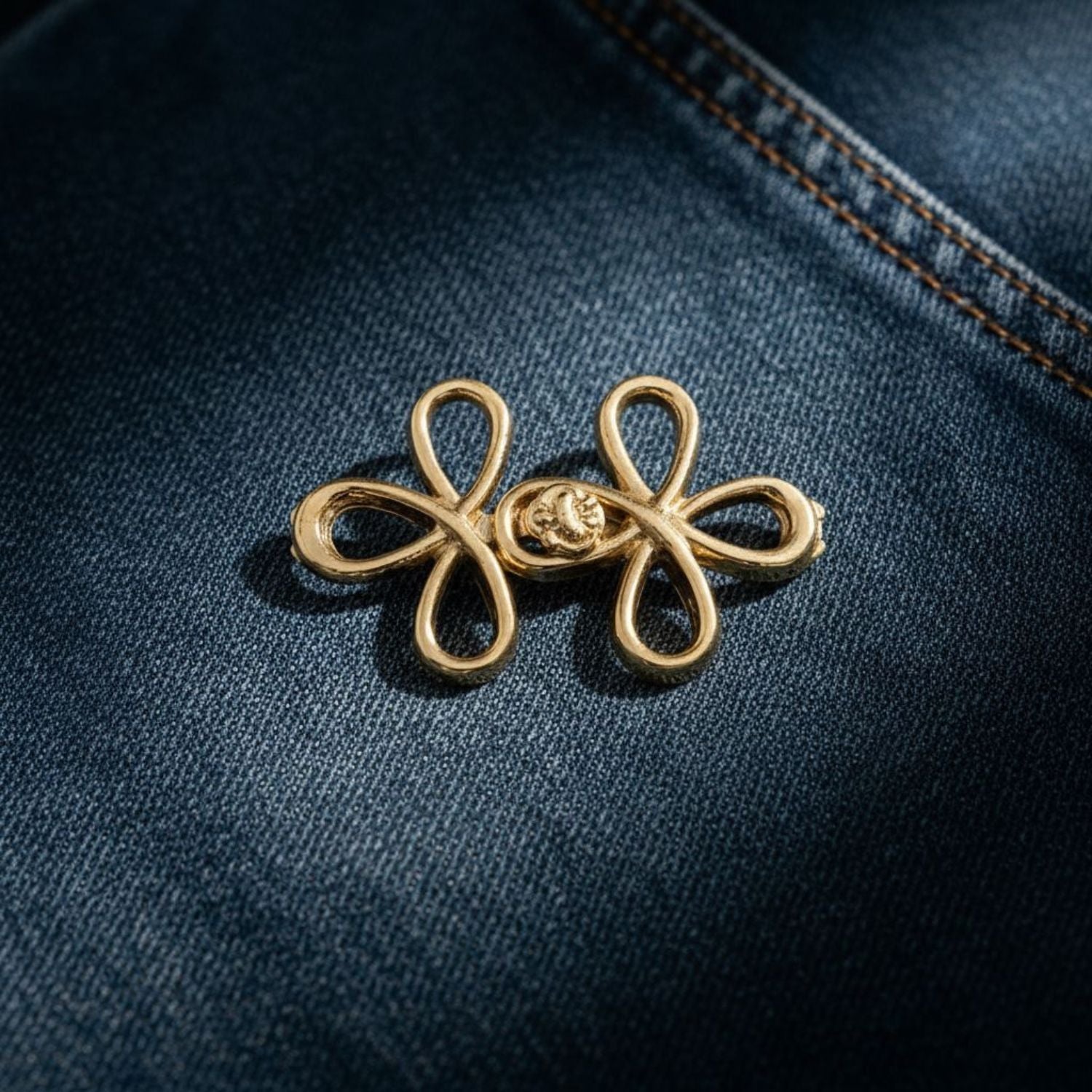 Gold brooch on a dark blue denim background