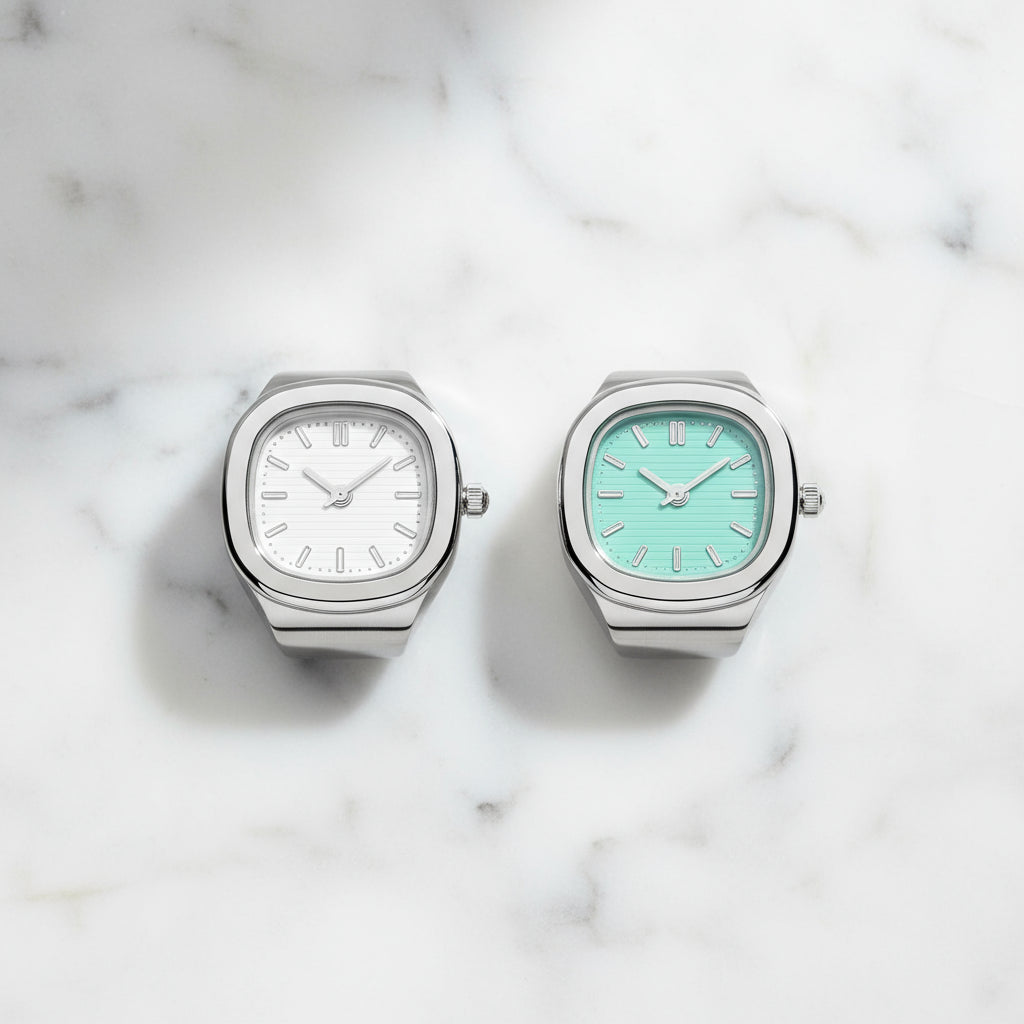 Two watches with different colored faces on a marble surface