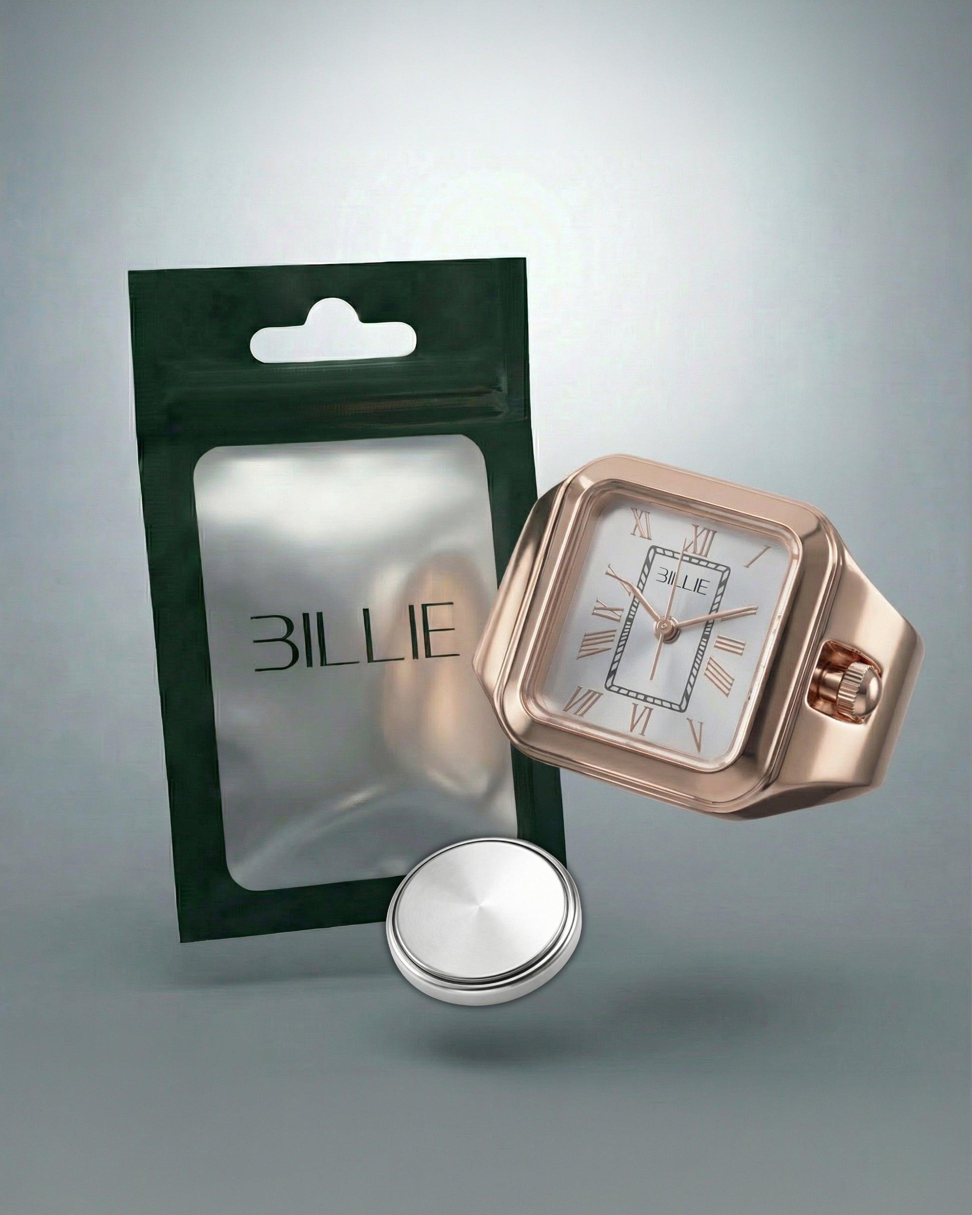 A rose gold watch next to a green packaging and a silver button battery.