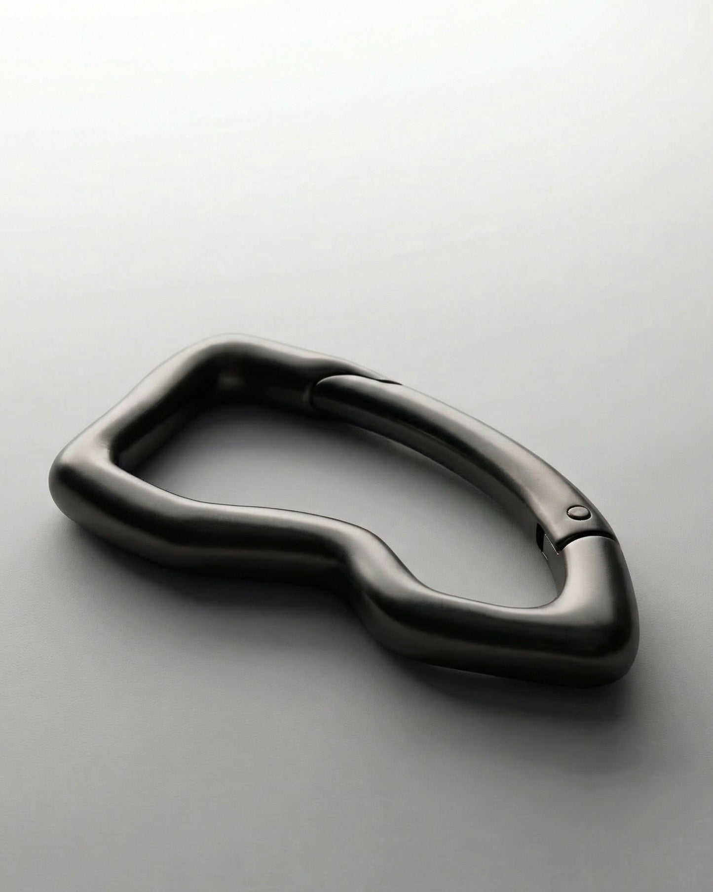 Black, abstract-shaped object on a light background.