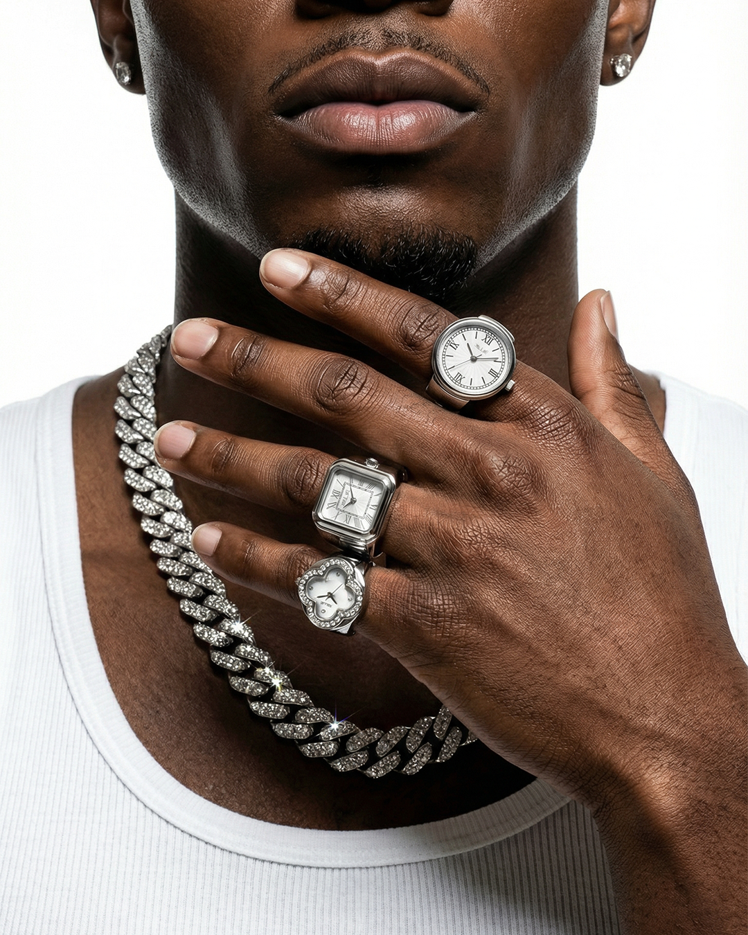 Man wearing multiple diamond rings and a watch on a white background