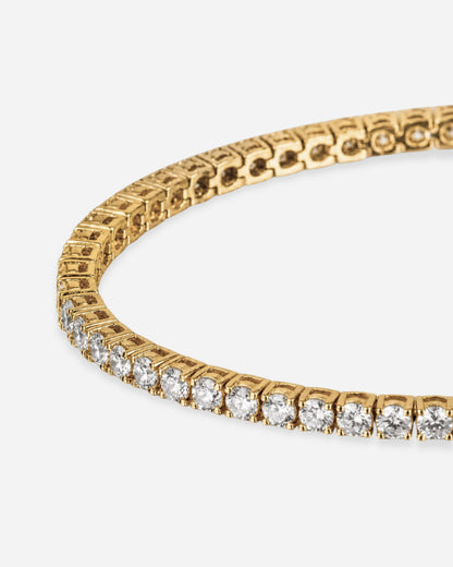 Close-up of a gold bracelet with clear stones set in a row.