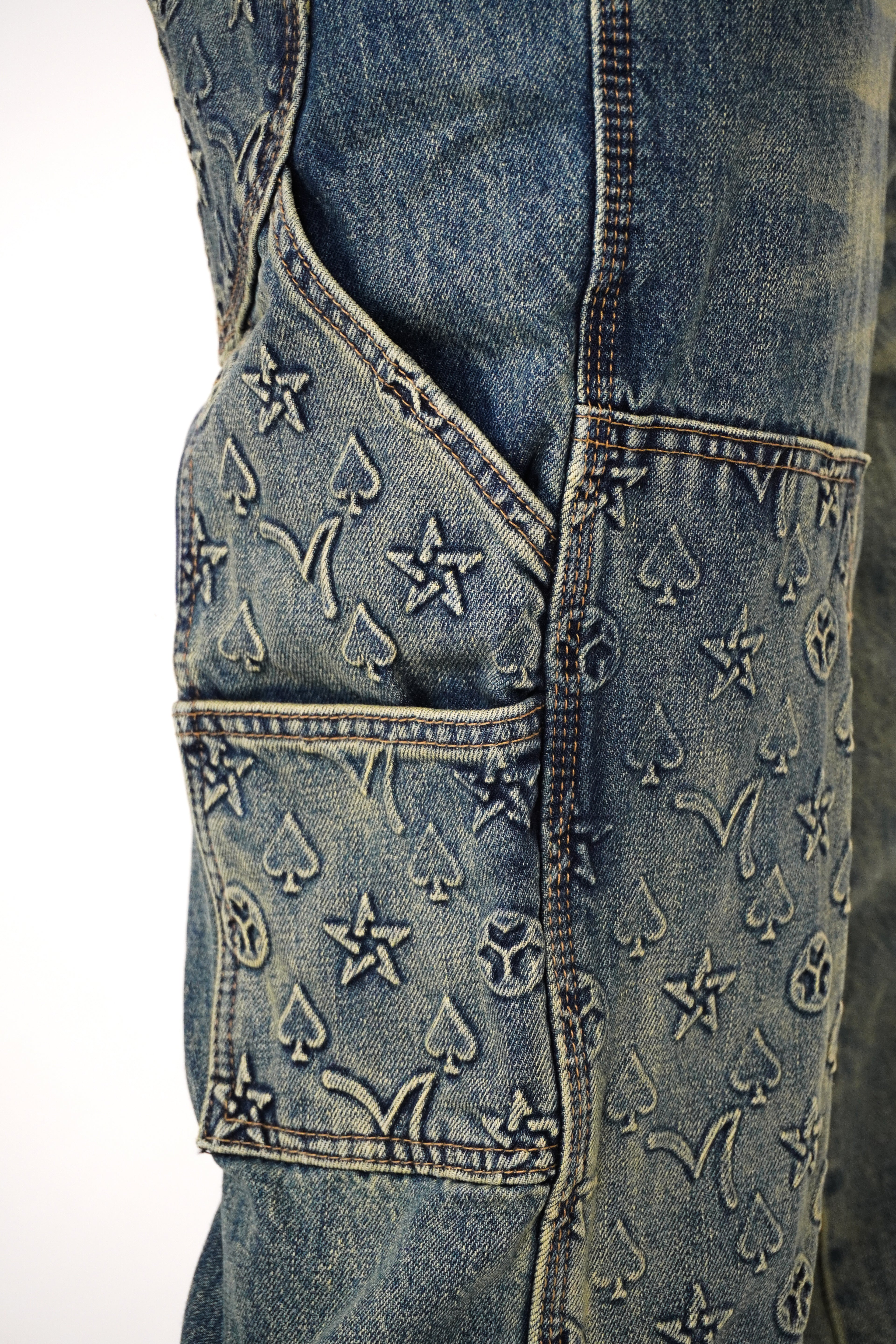 Close-up of a denim vest with embroidered patterns on a white background