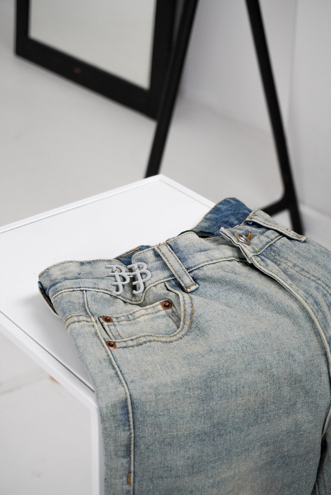 Light blue jeans on a white surface with a blurred background