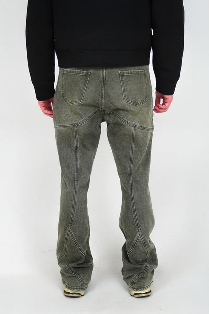 Person wearing green jeans and a black sweater on a white background