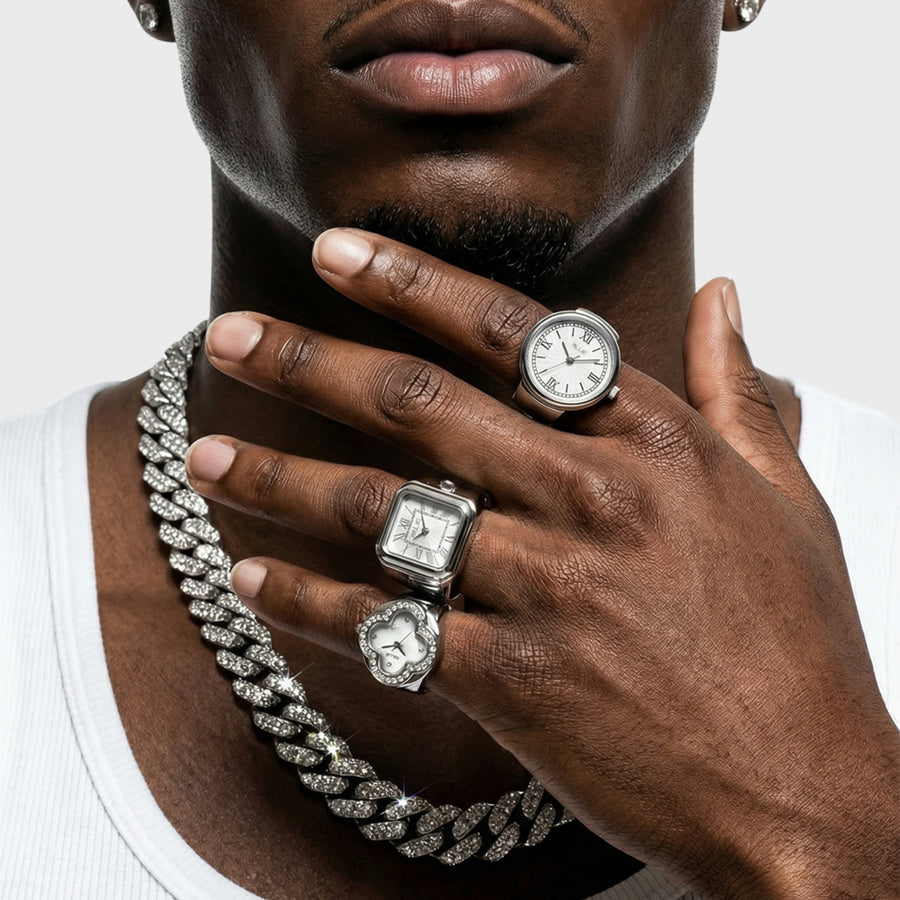 Man wearing multiple diamond rings and a chain necklace on a white background