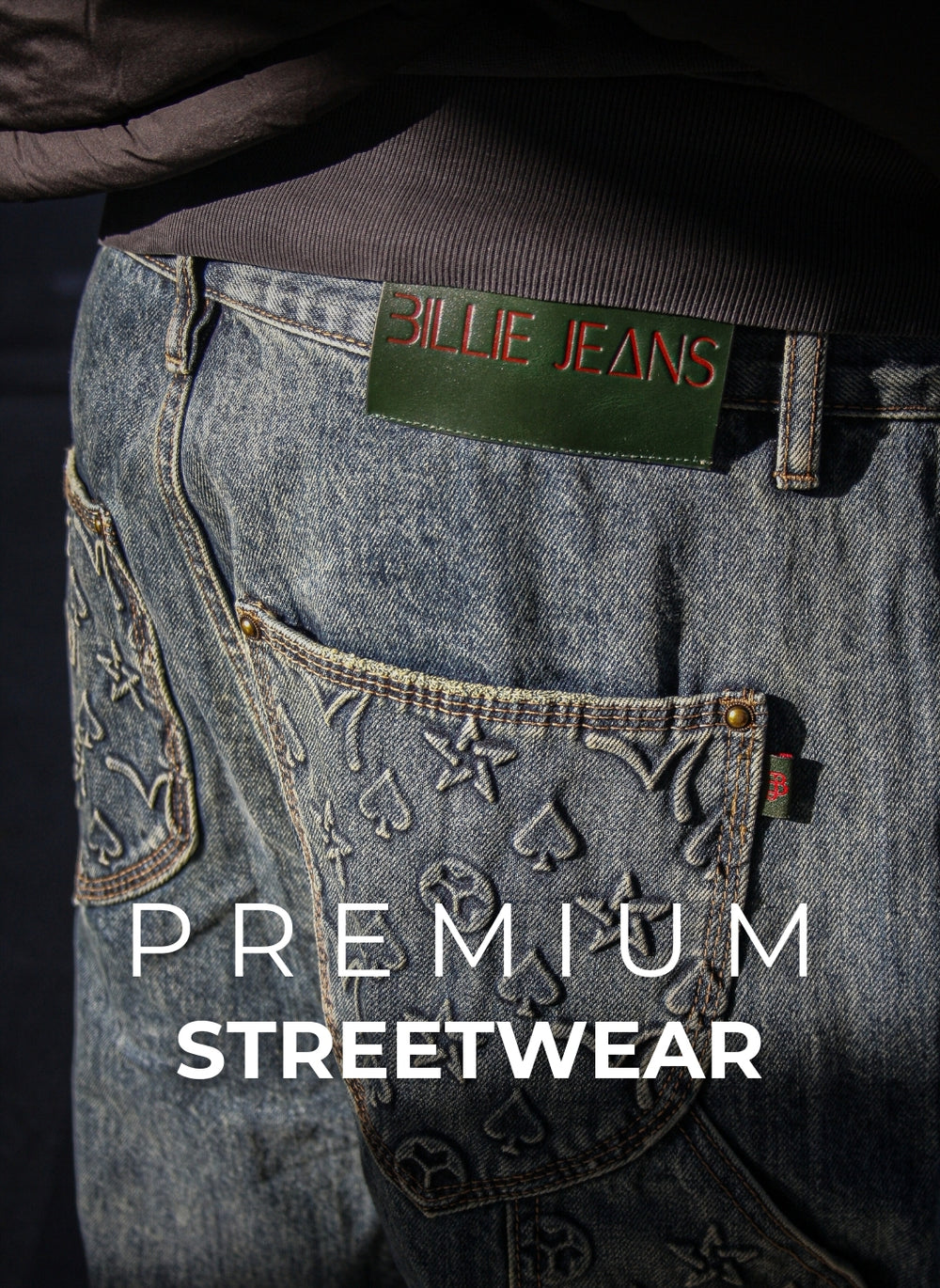 Close-up of a person wearing blue jeans with a Billie Jeans label, text 'Premium Streetwear' on a dark background.