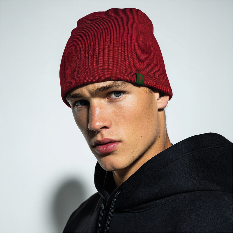 Man wearing a red beanie and black jacket against a light gray background