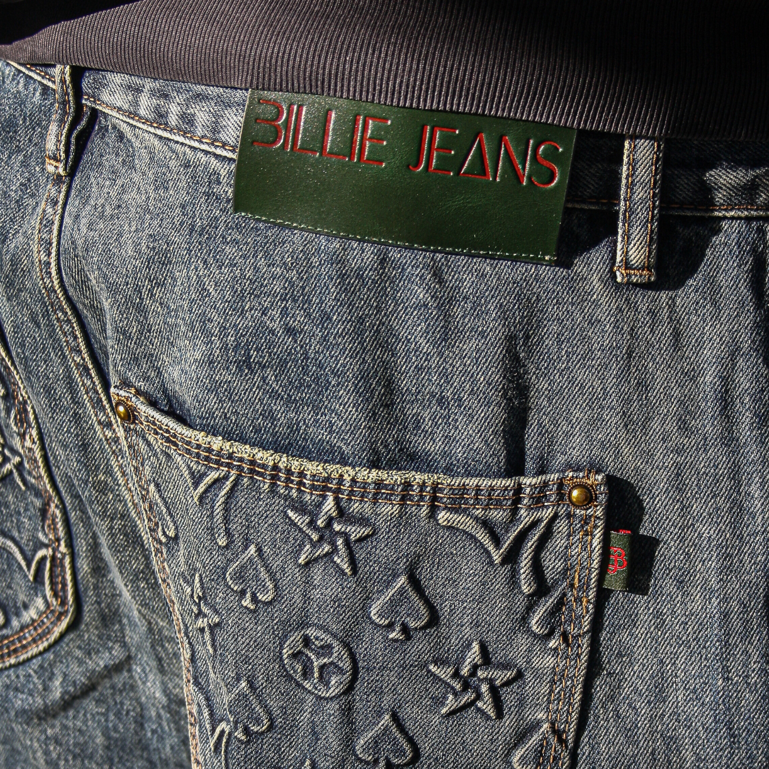 Close-up of a denim pocket with 'Billie Jeans' label on a dark background
