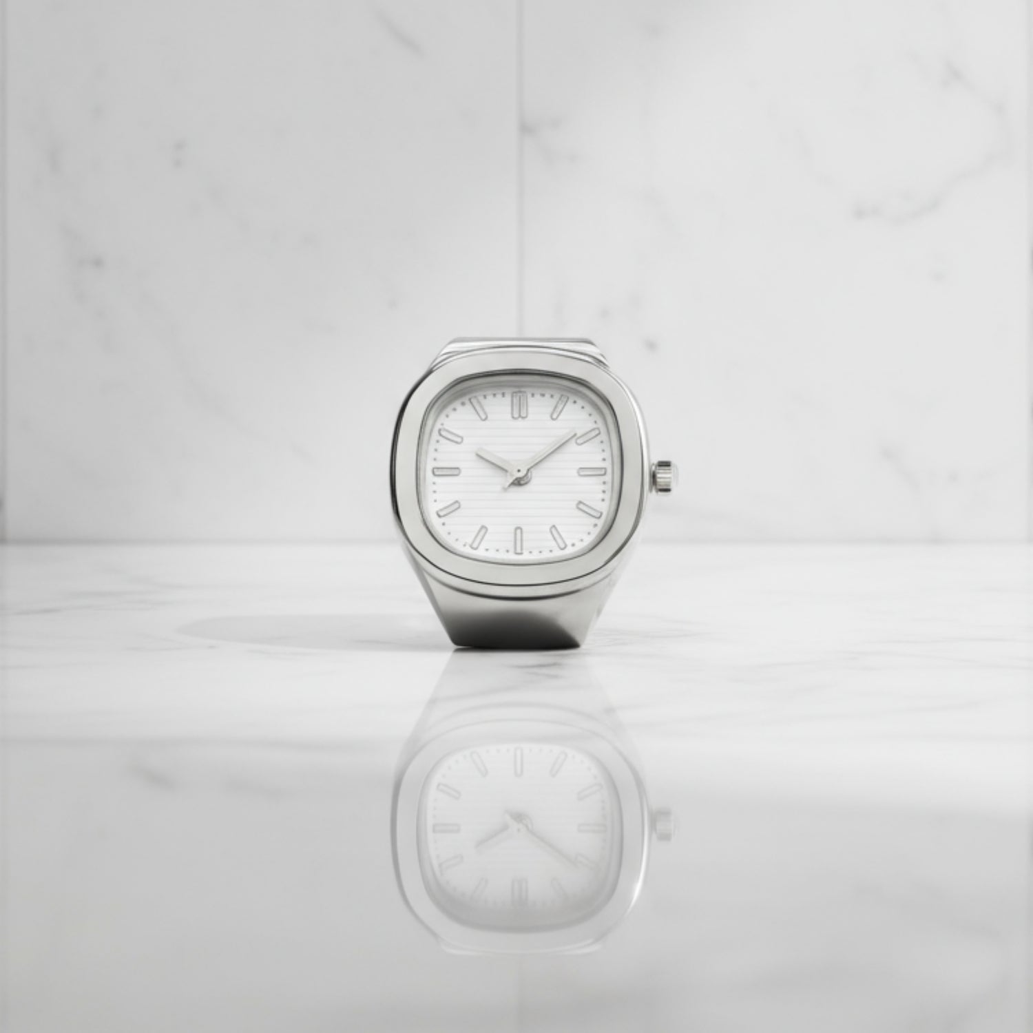 Silver ring watch with a white face on a light gray background