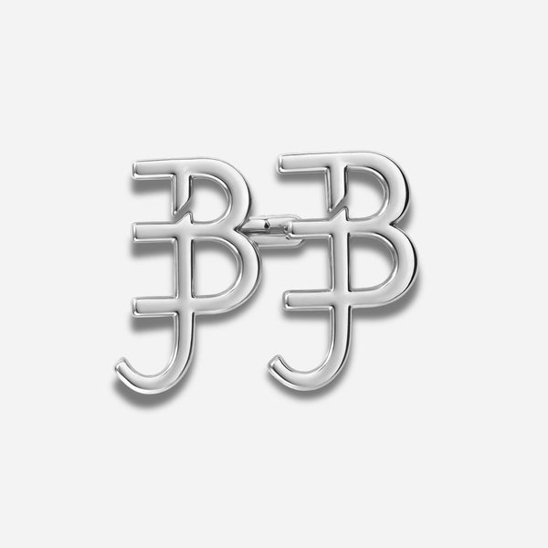 Silver letter 'BJ' brooch on a light gray background