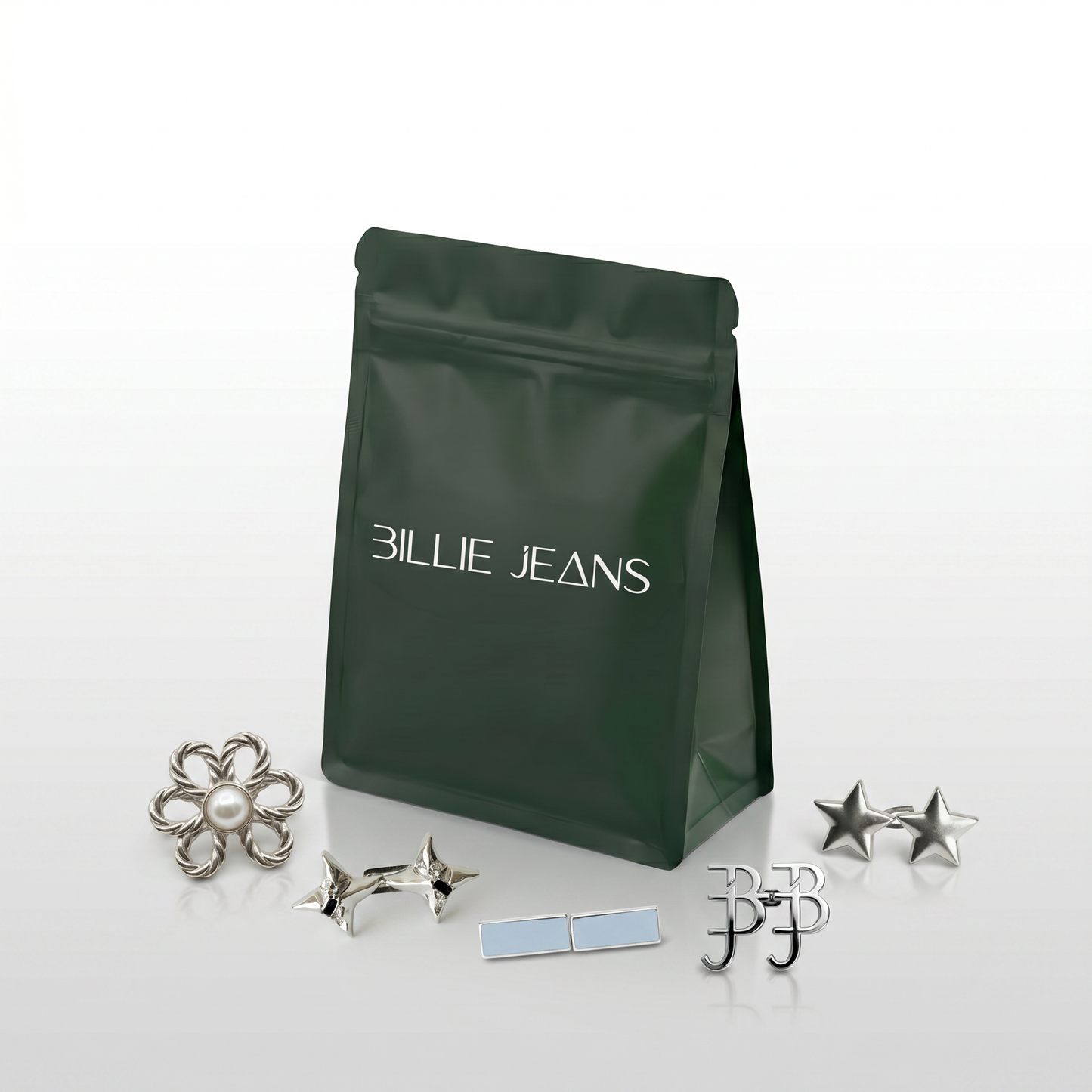 Billie Jeans dark green branded pouch with a collection of silver jeans pins including flower pearl, star, BJ monogram and rectangle designs